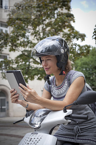 Frau auf Roller mit Ipad