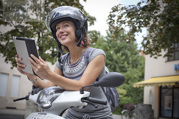 Frau auf Roller mit Ipad