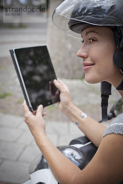 Frau auf Roller mit Ipad