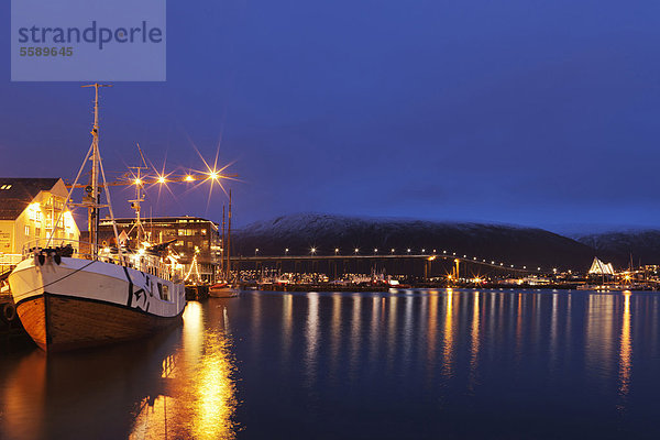 Blick auf das Hafengebiet in der Nähe des Troms¯ Polarmuseet  Polarmuseums  mit der beleuchteten Troms¯-Brücke hinten  Troms¯  Tromso  Norwegen  Europa