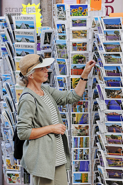 Touristin betrachtet Postkarten an Andenkenladen in Sault  Vaucluse  Provence-Alpes-Cote d'Azur  Südfrankreich  Frankreich  Europa  ÖffentlicherGrund