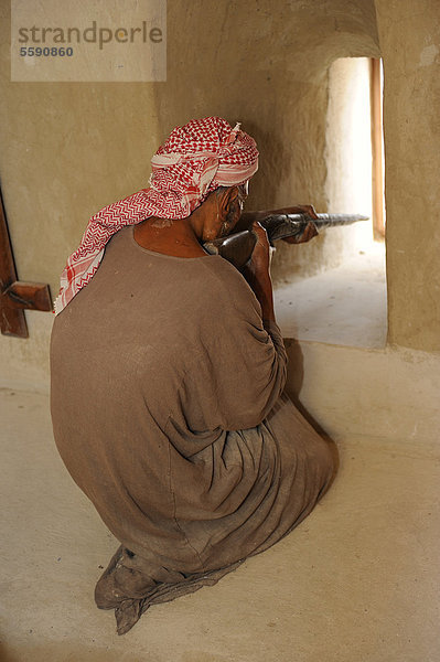 Araber-Puppe  als arabischer Krieger gekleidet  schießt aus einer Schießscharte  Oase und Enklave Hatta  Heritage Village  Vereinigte Arabische Emirate  Arabische Halbinsel  Naher Osten