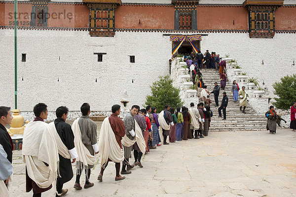 Tibetischer Buddhismus  Festival  Menschen in Gho Tracht stehen in einer Schlange an  Klosterfestung Rinpung Dzong  Paro  Himalaja  Königreich Bhutan  Südasien  Asien
