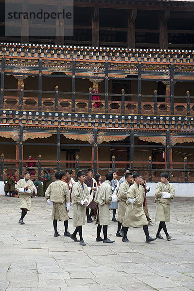 Tibetischer Buddhismus  Festival  Männer in Gho Tracht  Klosterfestung Rinpung Dzong  Innenhof  Paro  Himalaja  Königreich Bhutan  Südasien  Asien