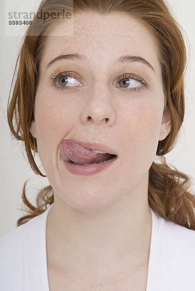 Junge Frau  die die Zunge herausstreckt  Nahaufnahme