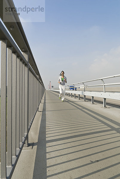 Deutschland  Nordrhein-Westfalen  Düsseldorf  Junge Frau läuft auf Brücke
