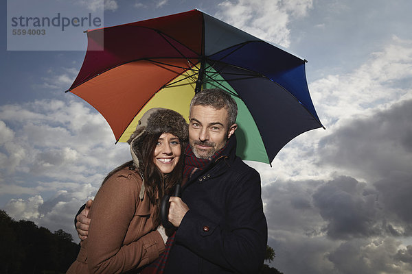 Deutschland  Köln  Paar mit Schirm  lächelnd  Portrait