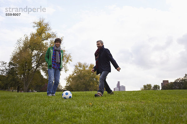 Mann spielt Fußball im Park  lächelnd