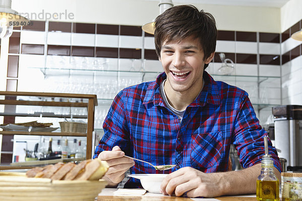 Junger Mann beim Essen  lächelnd  Porträt