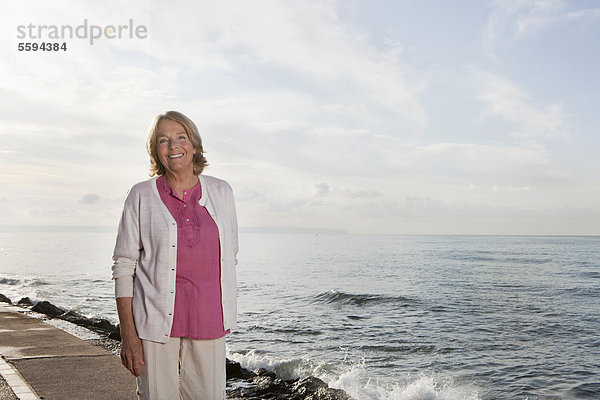Spanien  Mallorca  Seniorin am Meer stehend  lächelnd  Portrait