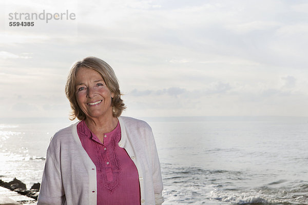 Spanien  Mallorca  Seniorin am Meer stehend  lächelnd  Portrait