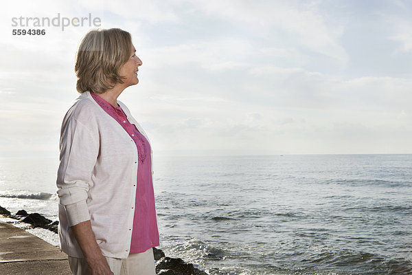 Spanien  Mallorca  Seniorin am Meer stehend  lächelnd