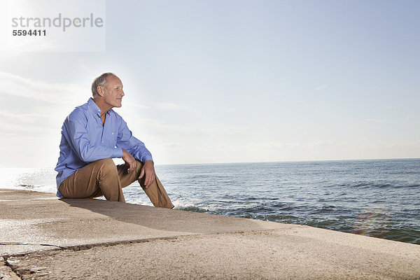 Spanien  Mallorca  Senior Mann am Meer sitzend