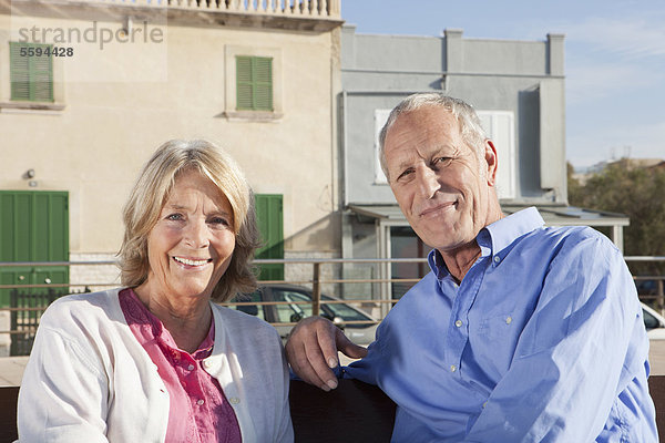 Spanien  Mallorca  Seniorenpaar auf Bank sitzend  lächelnd  Portrait