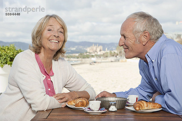 Spanien  Mallorca  Seniorenpaar im Restaurant am Strand  lächelnd