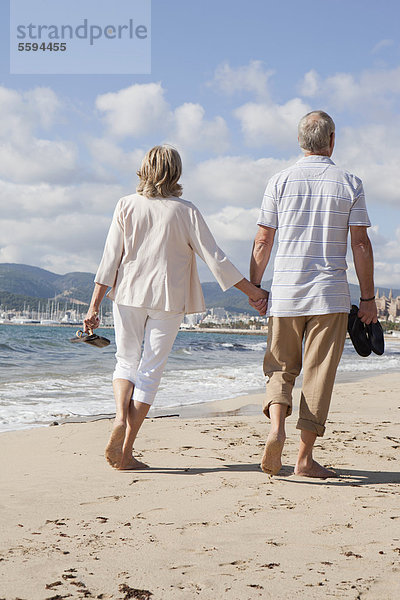 Spanien  Mallorca  Seniorenpaar am Strand entlang