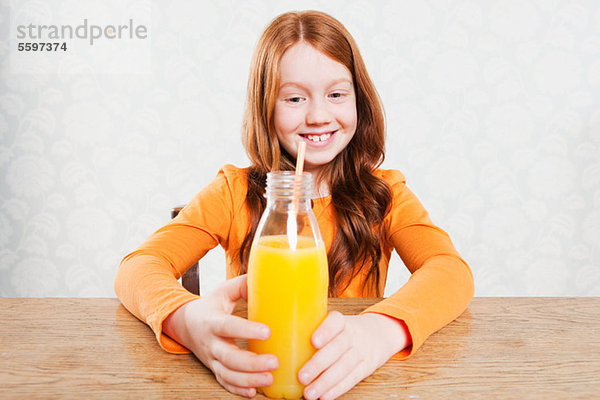 Mädchen mit Flasche Orangensaft