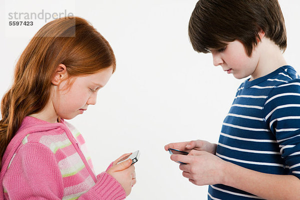 Junge und Mädchen schauen auf Smartphones