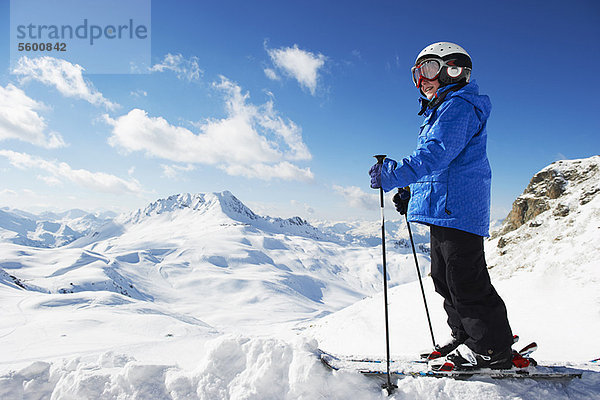 Junge in Skiern auf verschneiter Bergspitze