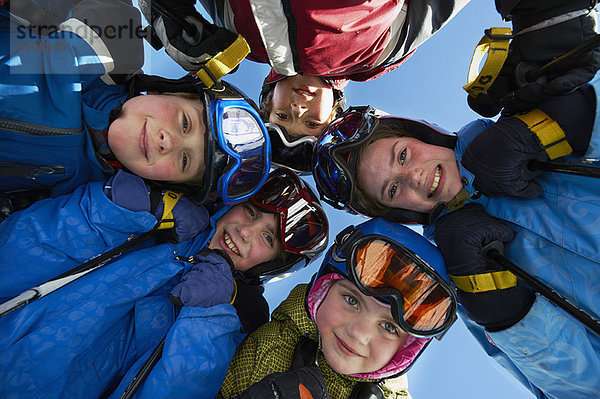 Kinder in Skiausrüstung stehen zusammen