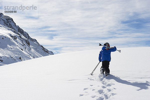 Kind mit Skiern auf schneebedecktem Berg