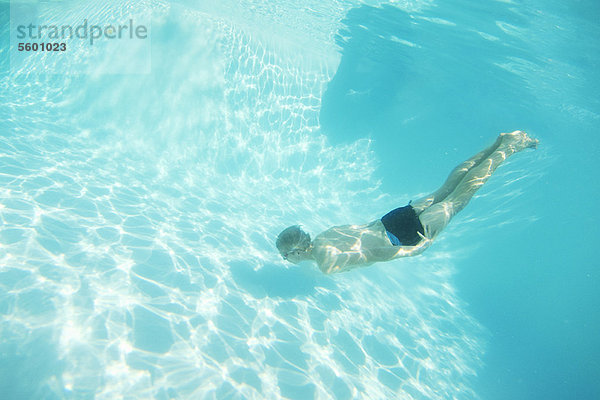 Junge mit Brille schwimmt im Pool