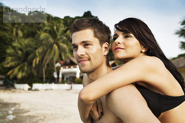 Mann mit Freundin am Strand