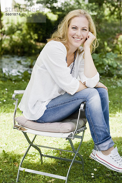 Lächelnde Frau im Freien sitzend