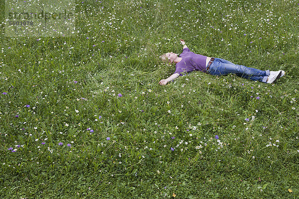 Lächelnde Frau im Gras liegend