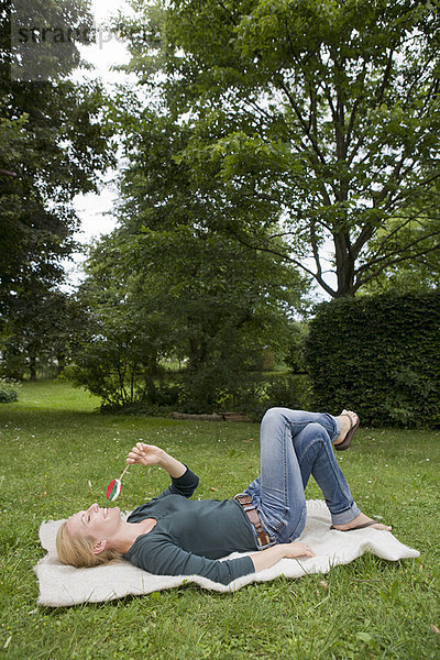 Frau entspannt sich auf der Decke im Gras