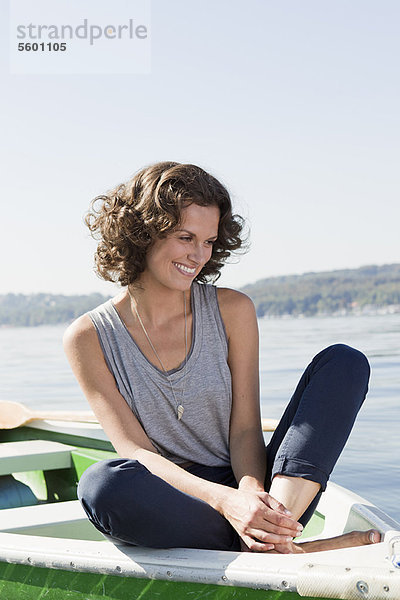 Frau sitzend im Boot im stillen See