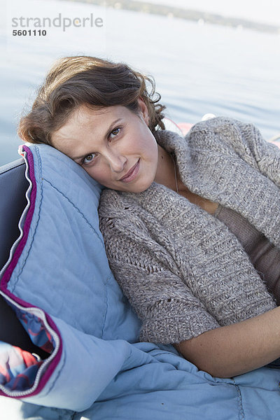 Frau entspannt im Boot auf dem stillen See