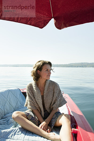 Frau entspannt im Boot auf dem stillen See