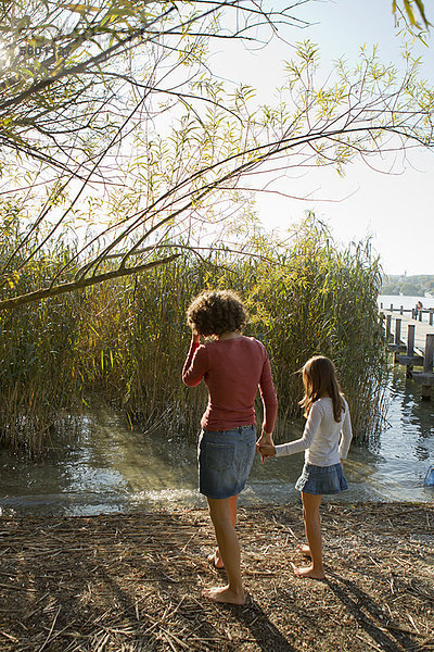 Mutter und Tochter beim Spaziergang am See