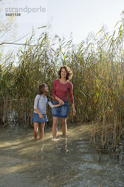 Mutter und Tochter beim Spaziergang im Teich