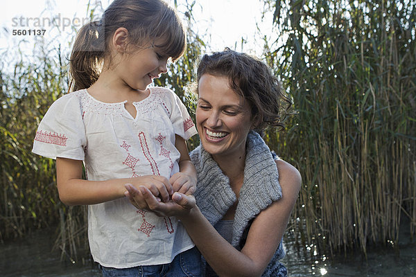 Mutter und Tochter reden im Teich