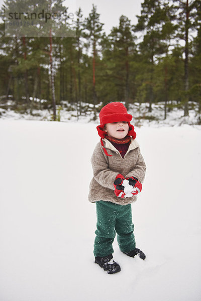 Junge spielt im Schnee im Freien