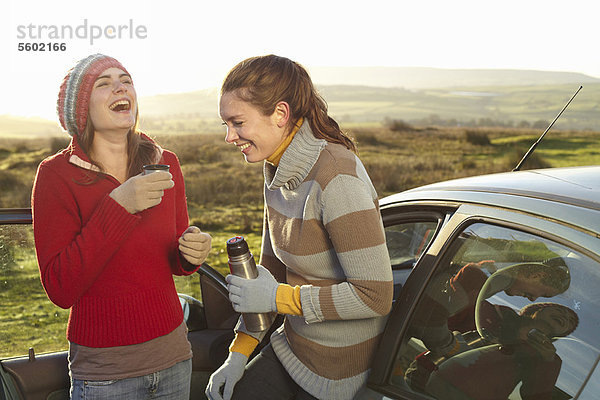 Frauen trinken Kaffee aus der Thermoskanne