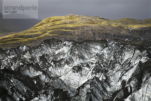 Mit Moos bewachsener Hügel hinter der Gletscherzunge SÛlheimajökull vom Gletscher M_rdalsjökull  nahe Skogar  Island  Europa