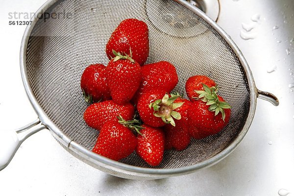 Sieb mit Erdbeeren im Waschbecken