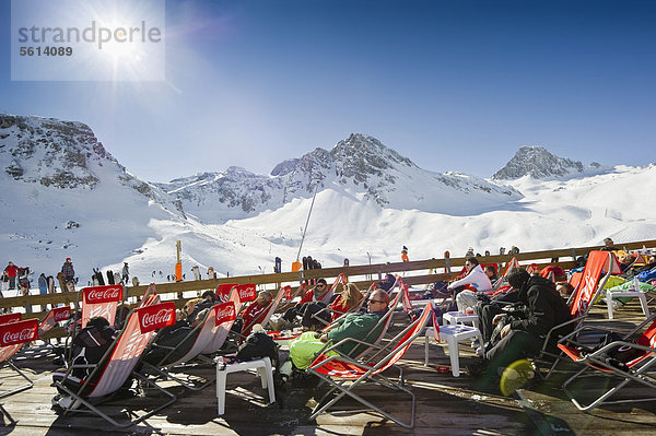 Skifahrer rasten im Sonnenschein mit Blick auf die verschneiten Berge  Tignes  Val d'Isere  Savoien  Alpen  Frankreich  Europa