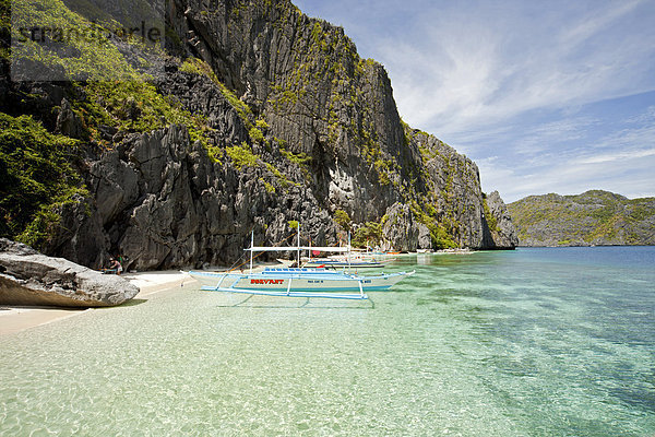 Auslegerboot vor der steilen Kalkstein-Küste von Tapiutan Island  Bacuit Archipel  El Nido  Palawan  Philippinen  Asien