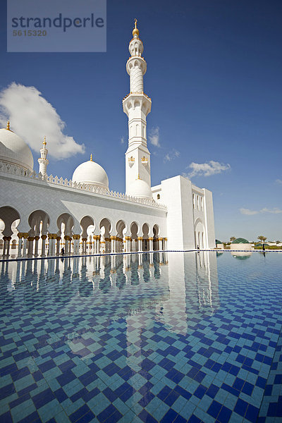 Minarett und Säulengang spiegeln sich in einem Wasserbecken der Sheikh Zayed Moschee in Abu Dhabi  Vereinigte Arabische Emirate  Asien