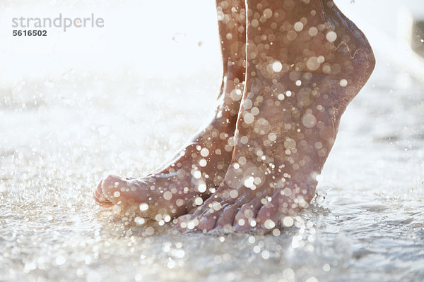 Füße unter der Dusche im Freien