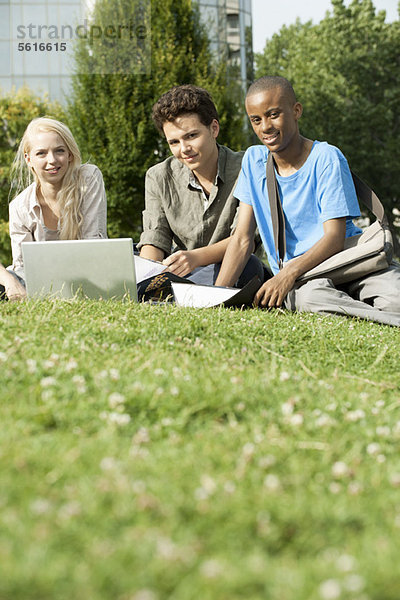 Universitätsstudenten  die gemeinsam auf Rasen studieren  Blickwinkel niedrig