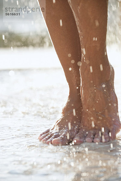 Füße unter der Dusche im Freien