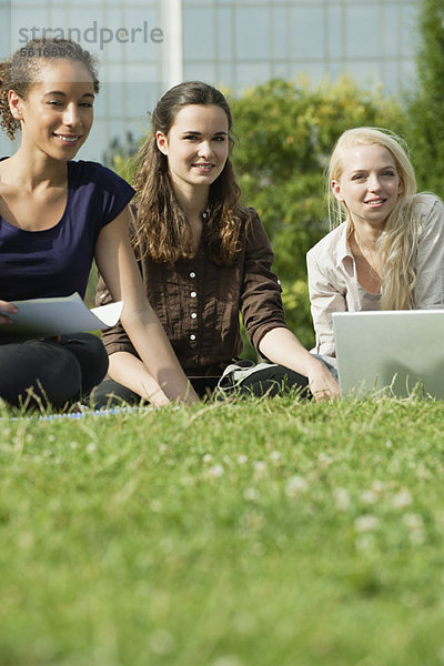 Studentinnen studieren gemeinsam auf Rasen  Blickwinkel niedrig