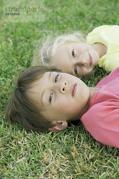 Junge und Mädchen auf Gras liegend  Portrait