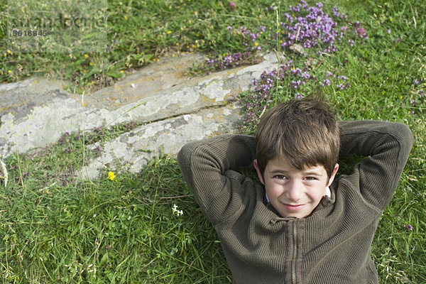 Junge entspannt auf Rasen  Portrait  direkt darüber