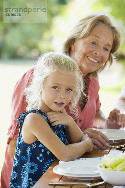 Mädchen beim Essen mit Großmutter im Freien